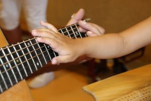 Muziektherapie-lachende-zon-gitaar-aanraking muziektherapie muziek gitaar